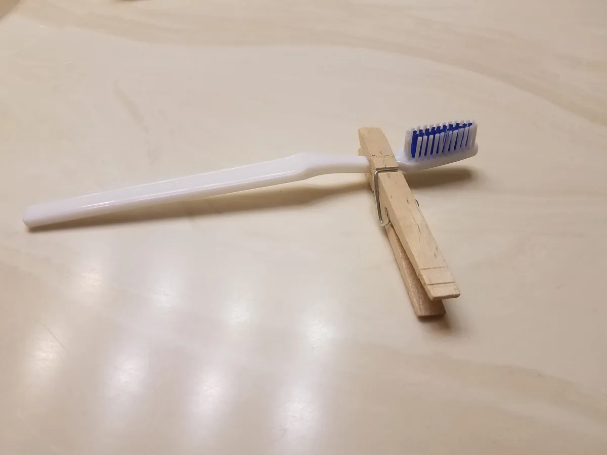 Using a clothespin to hold a toothbrush