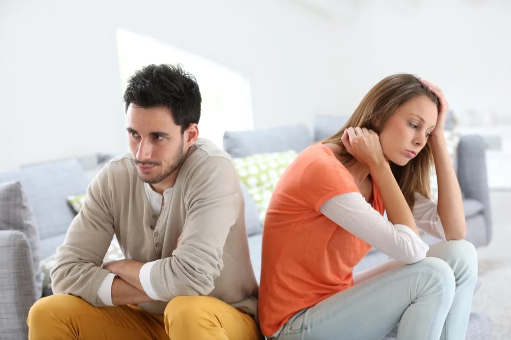 Couple arguing on the couch, things you should never say to your spouse