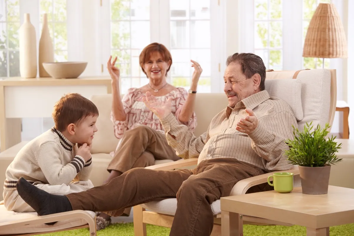 Grandparents telling grandchild a family story in living room