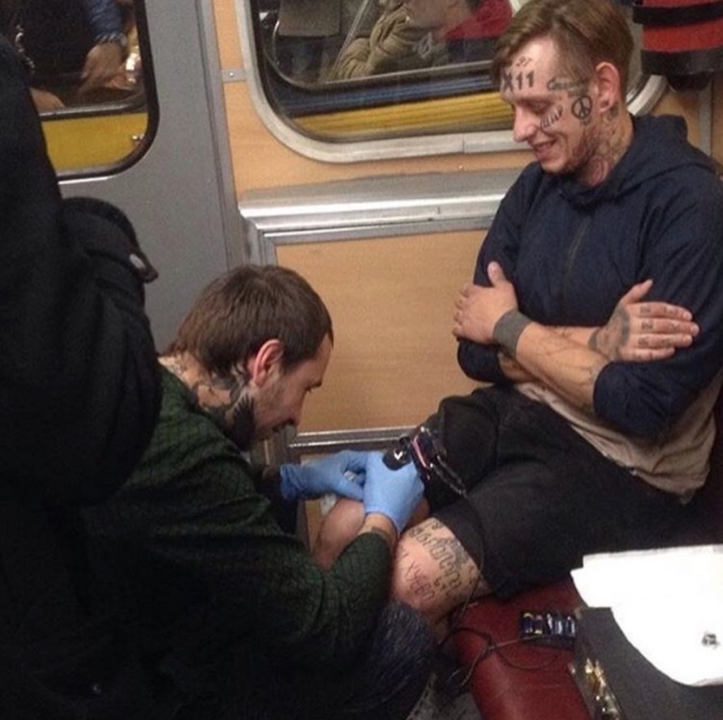 man getting tattoo on train