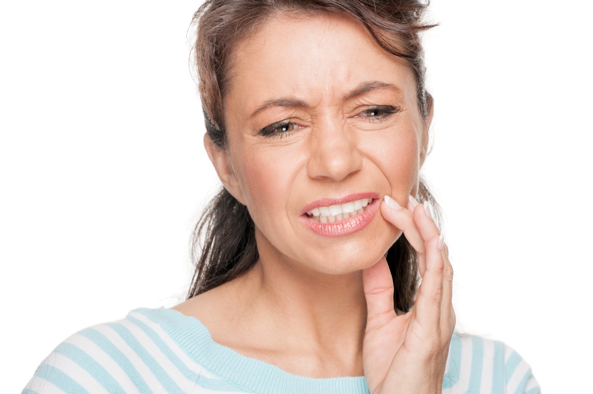 Woman holding her mouth due to a toothache