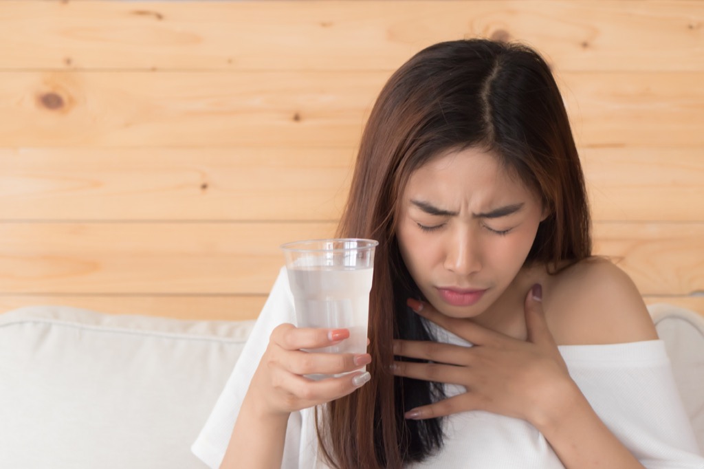 a woman drinking water learns how to get rid of hiccups