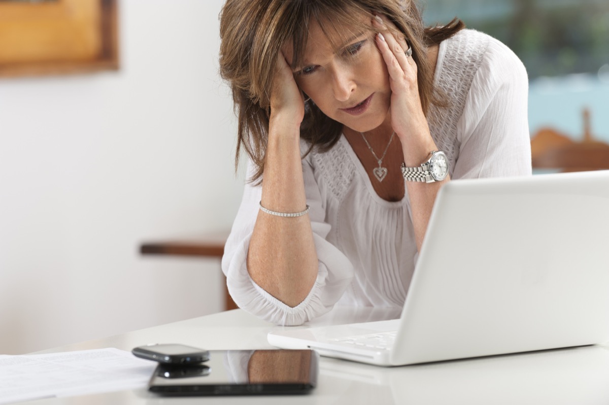 Worried middle-aged woman with technology at home
