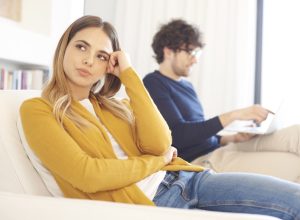 woman ignoring a man on a couch