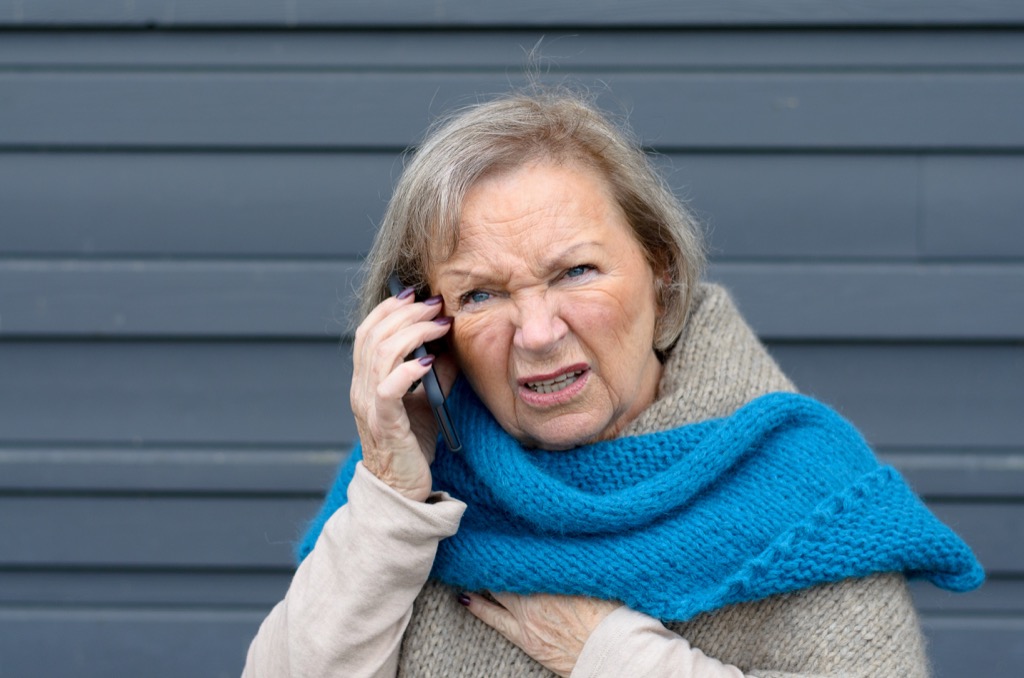 old woman is confused while having a conversation on the phone