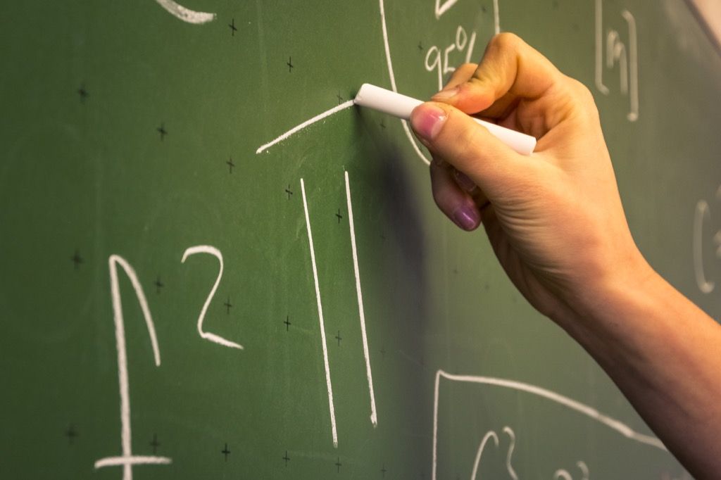 a hand writing out 6th grade math equations on a chalkboard {Tricky Math Questions}