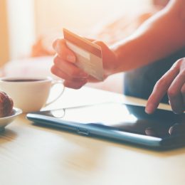 hands holding a credit card shopping online with a tablet