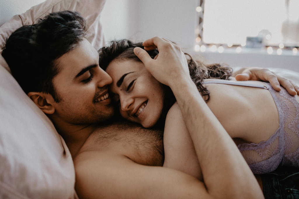 Latino Couple in Bed Reasons Smiling is Good for You