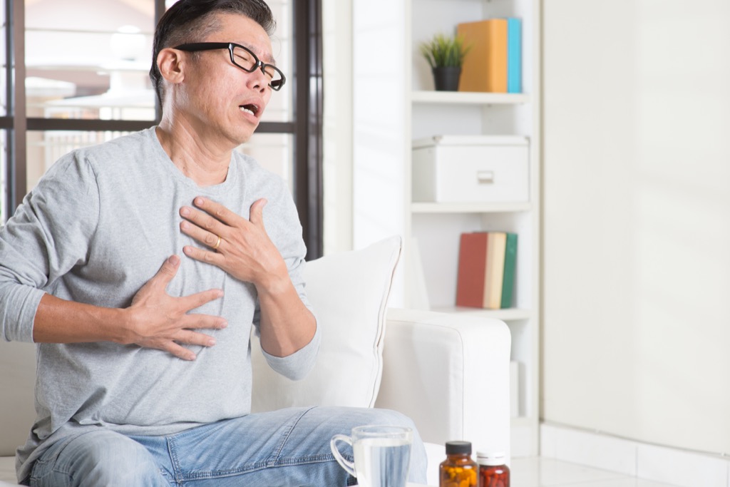 man clutching his chest and coughing