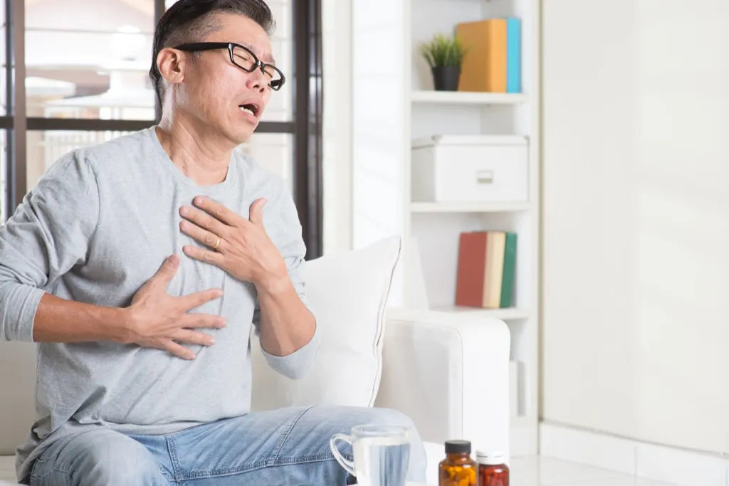 man clutching his chest and coughing men's health concerns over 40