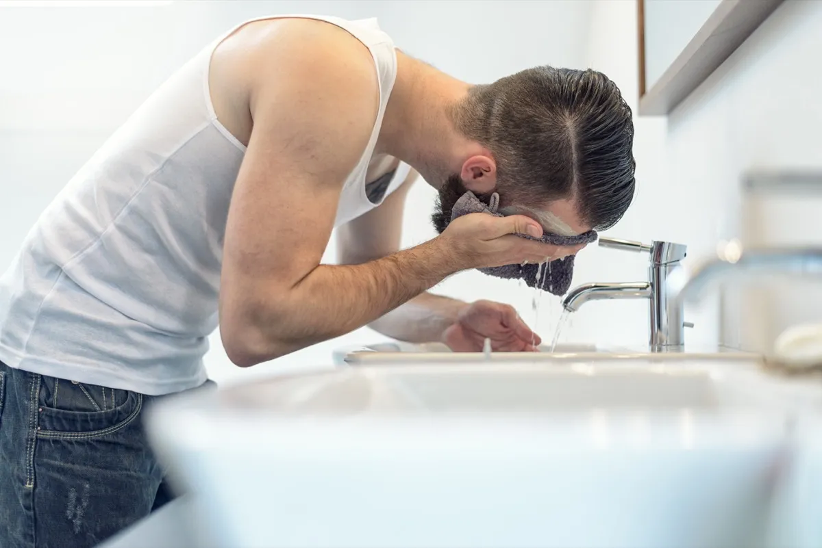 Man washing his face with a washcloth