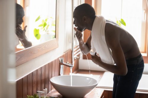 Man washing face at sink