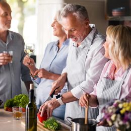 middle aged friends laughing in kitchen