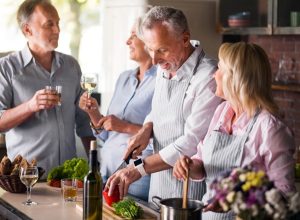 middle aged friends laughing in kitchen