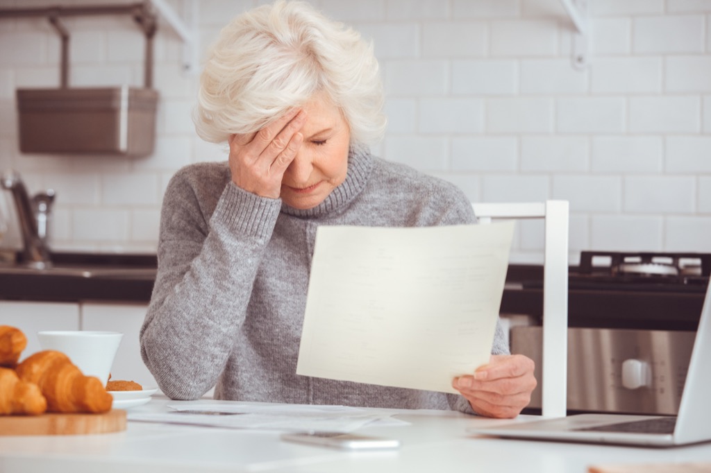 old woman is upset because she forgot to pay her bills