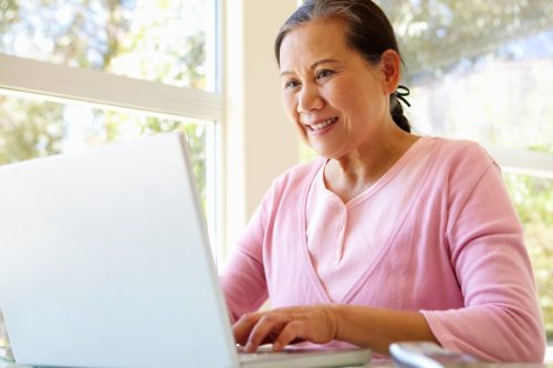 older woman on computer, learning a language is good for your brain