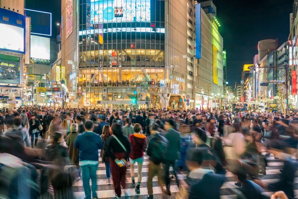 pedestrians walk across shibuya crossing in tokyo