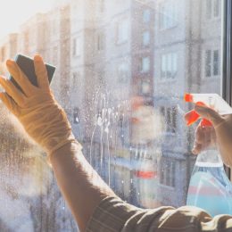 person cleaning a glass window, easy home tips