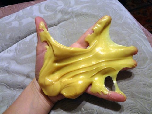 hand holding yellow silly putty