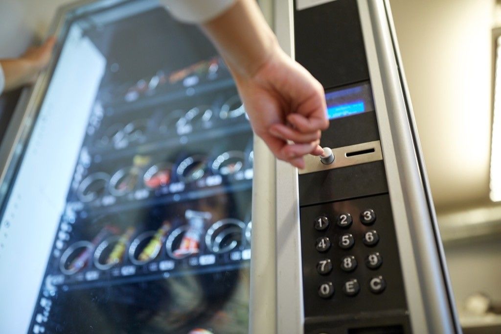 hand pointing to a vending machine