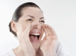 Mature woman shouting and screaming isolated over white background
