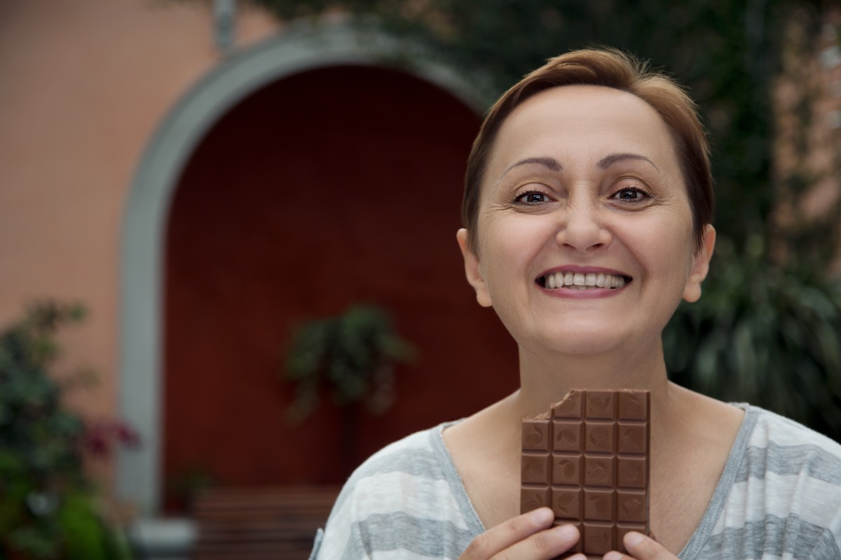 Older Woman Eating a Bar of Chocolate Lower Blood Pressure Naturally