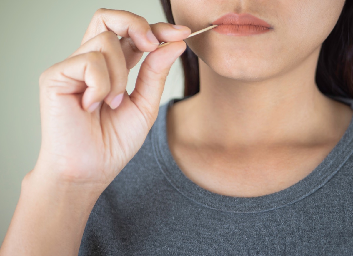 woman with toothpick in mouth, ways you're damaging teeth