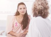 Woman wearing breast cancer ribbon at the doctor