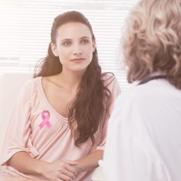 Woman wearing breast cancer ribbon at the doctor