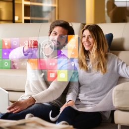couple sitting on a sofa playing with augmented reality smart home settings