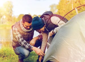 father and son setting up a tent