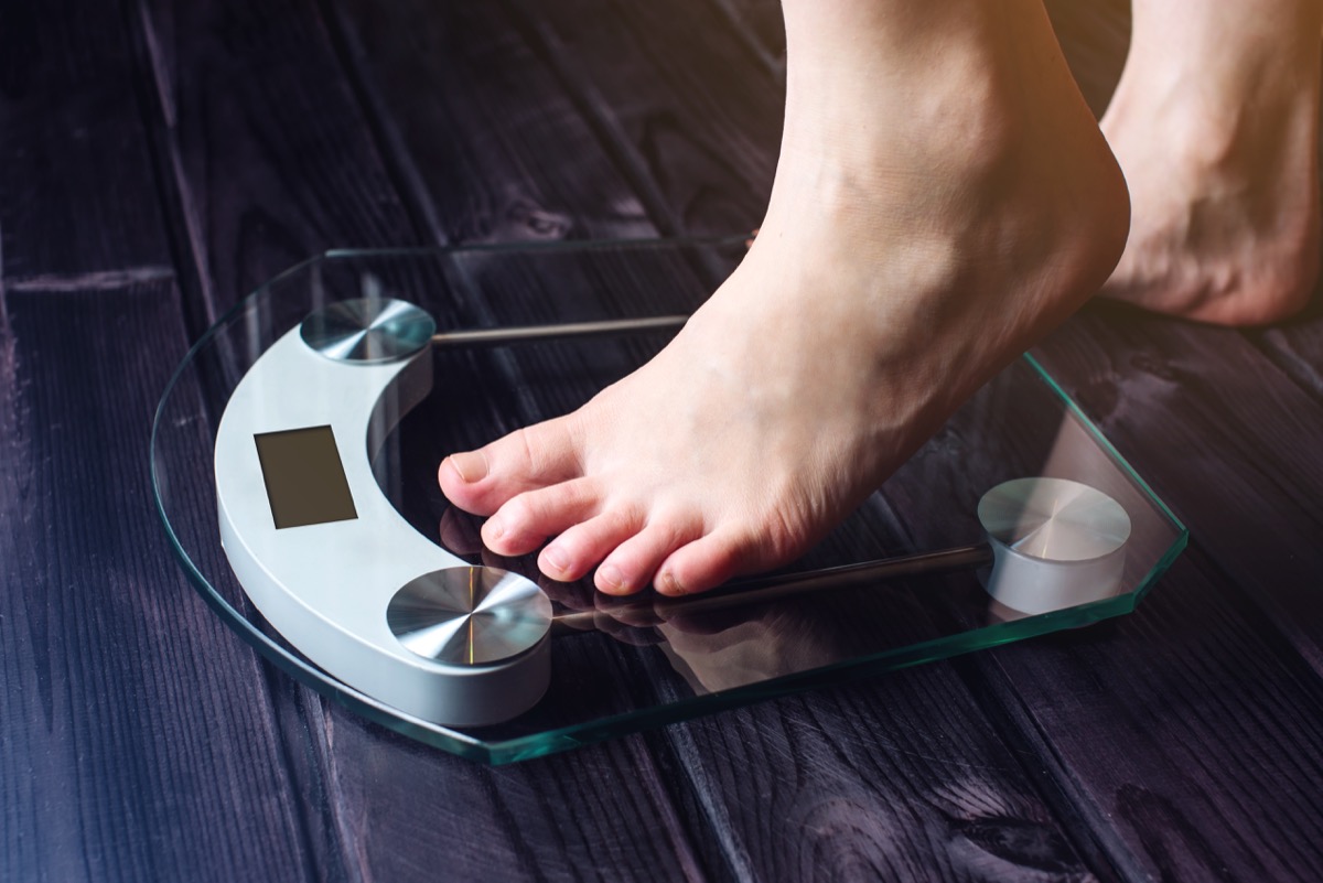 a person stepping on an electronic scale - terrible weight loss tips