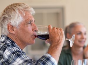 Mature man drinking a glass of red wine