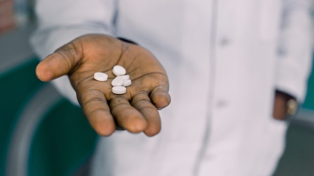 Man holding pills, medication, or vitamins