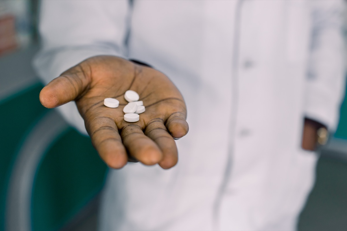 Man holding pills, medicine or vitamins