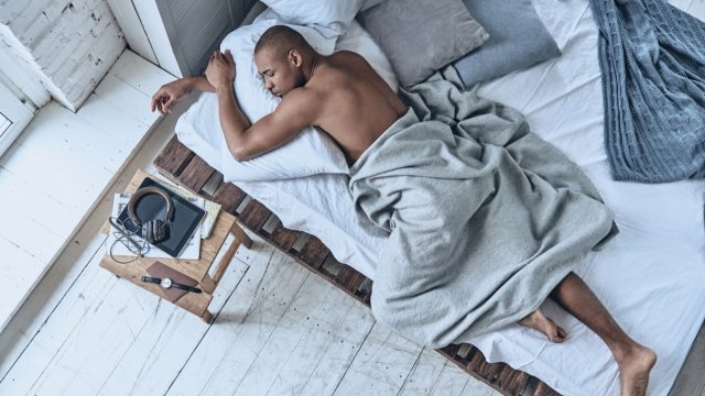 man sleeping on his stomach with his arms wrapped around a pillow - sleeping positions