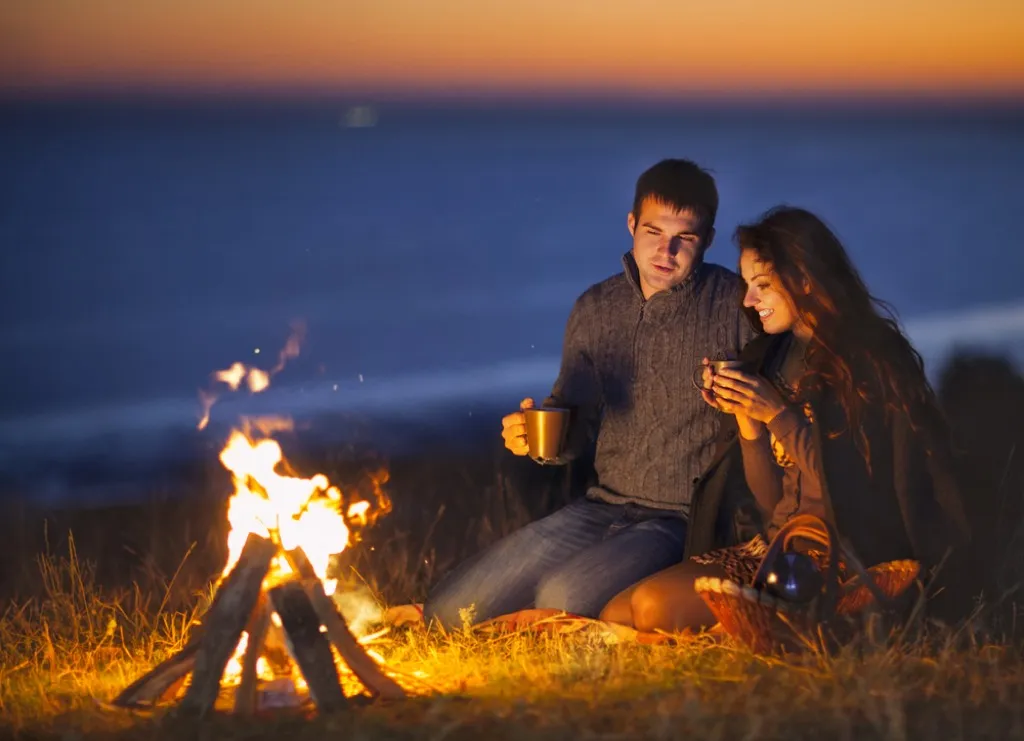 romantic experiences couple at a bonfire, date night ideas