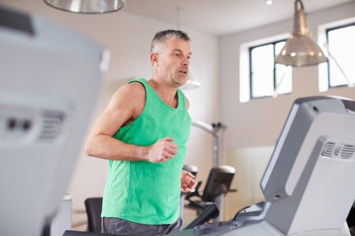 Mature white man running and doing cardio on the treadmill