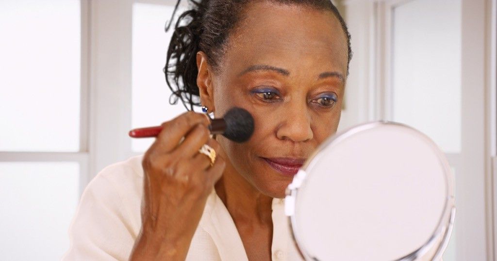 older woman putting on makeup, look better after 40