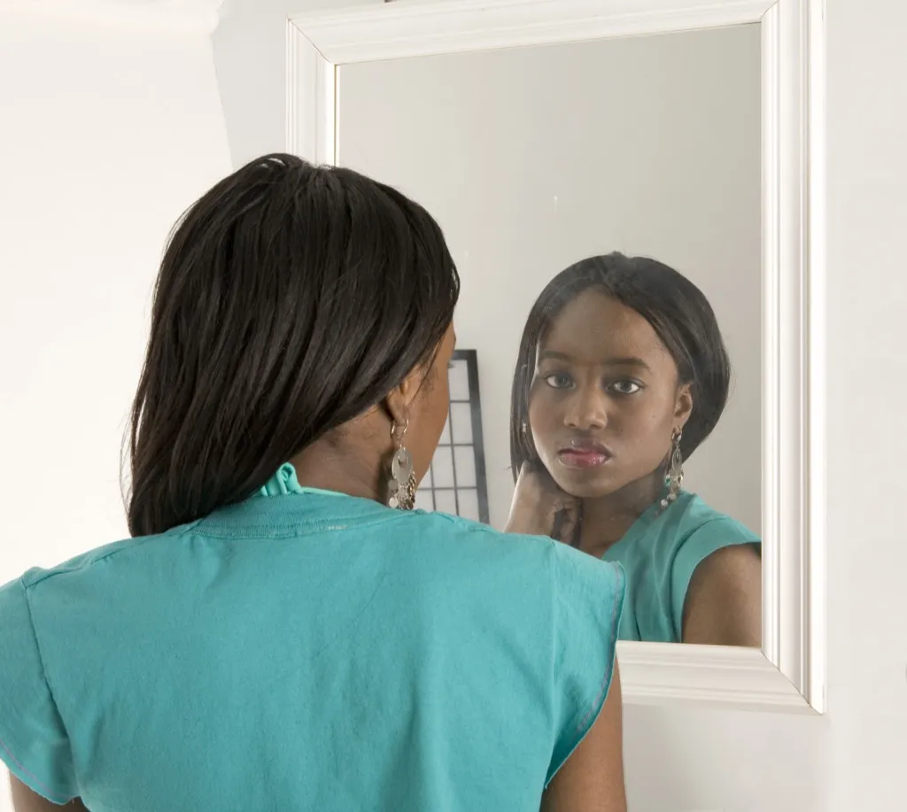 sad woman looking in mirror