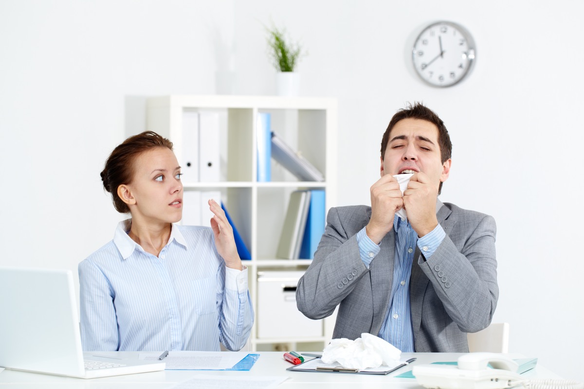 Man with a Cold Sneezing at Work {Common Cold Treatment}