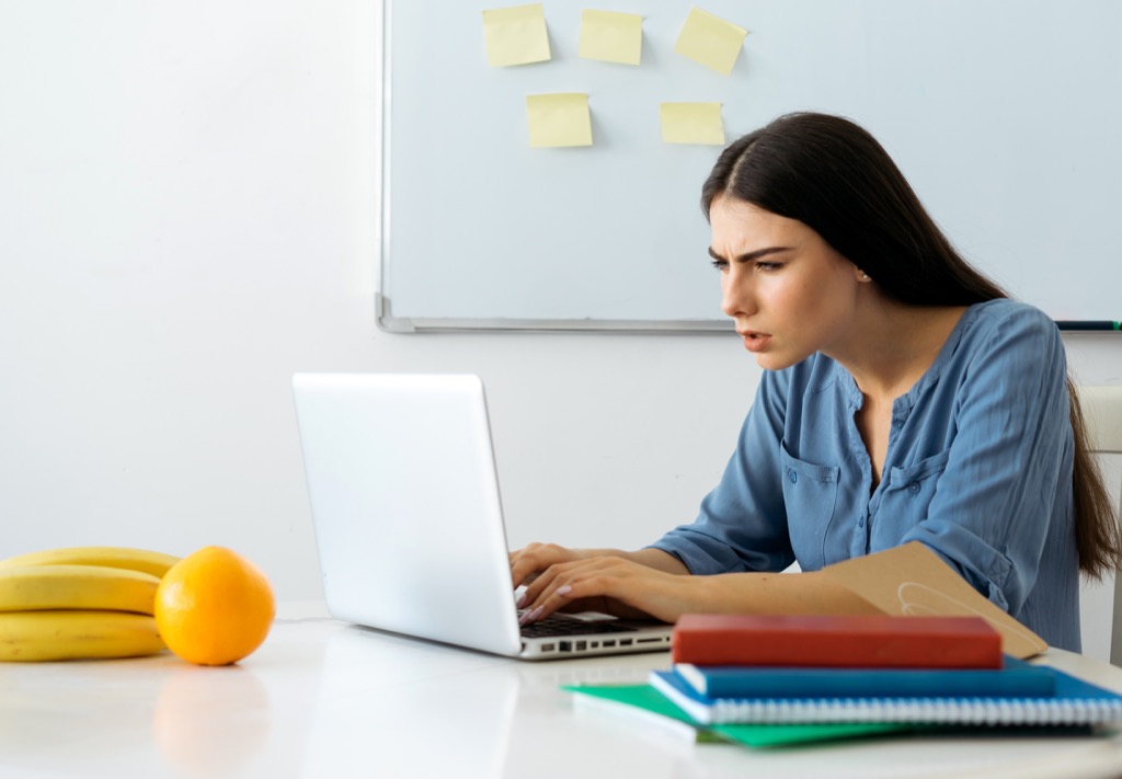 woman looking at her computer squinting