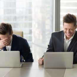 two guys at laptops laughing at anti-jokes