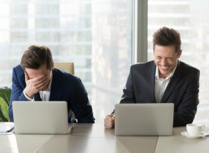 two guys at laptops laughing at anti-jokes