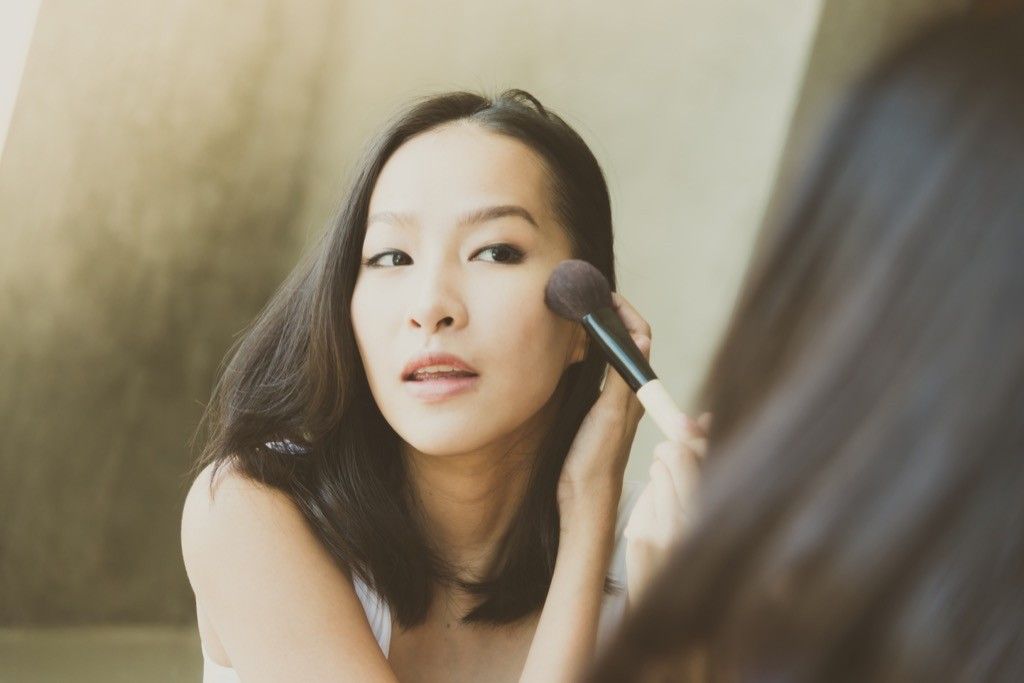 woman putting on makeup, working mom