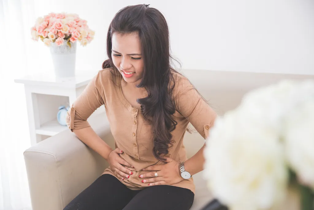 asian woman experiencing stomach pain