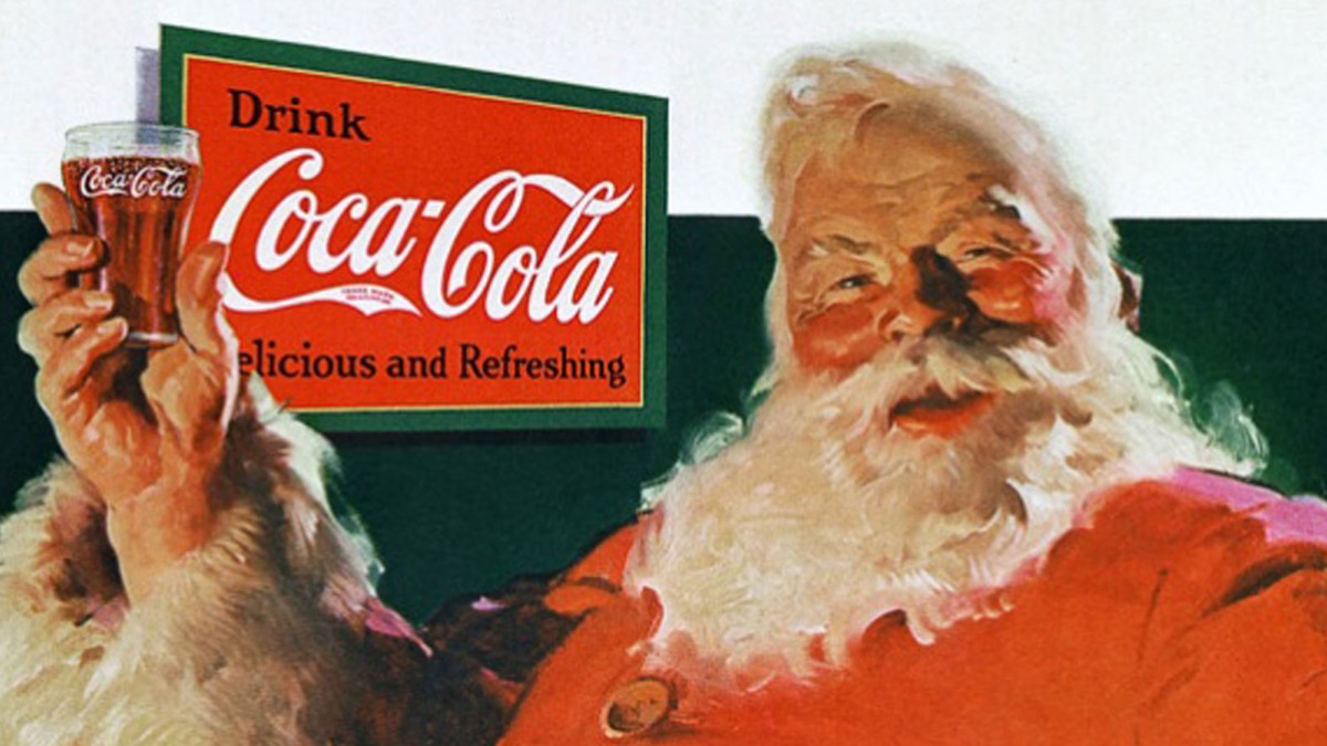 santa claus holding a glass of coca cola soda with a drink coca cola advertisement in the background
