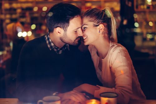 romantic young couple dating in pub at night