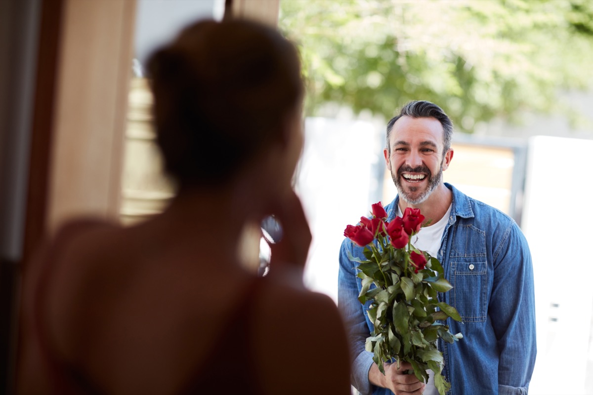 cropped shot of an attractive mature man surprising his girlfriend with a bouquet of roses
