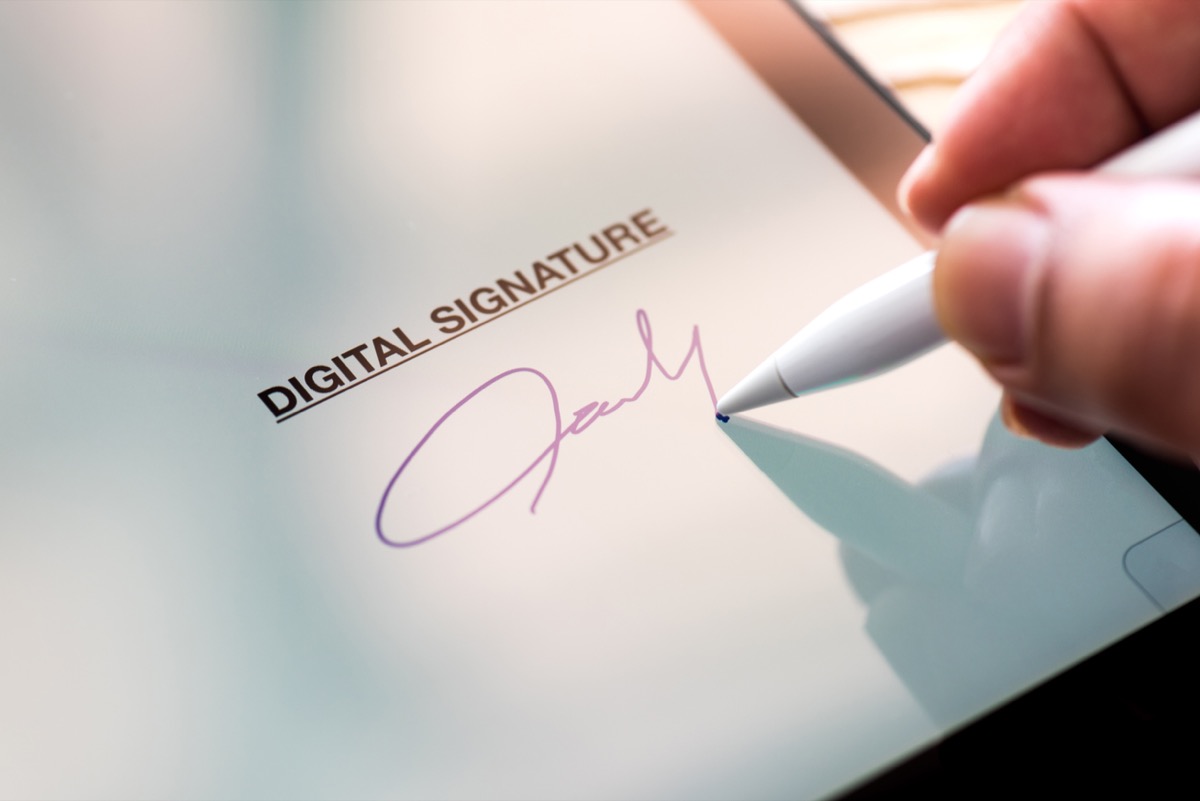 close up of someone signing on a tablet
